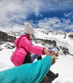 a woman sitting on top of a snow covered mountain