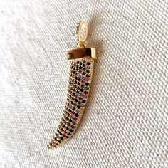 Exceptional design of Elephant Tusk pendant in 18k gold filled featuring colorful cubic zirconia on the tusk body and bail. Size: 2" length x 0.5" width Tusk jewelry symbolizes an elephant that has the strength to uproot a tree, but can also pick up a needle. Meaning that a person is wise and beyond duality. The elephant symbolizes mental strength. Wearing a tusk pendant asserts mental strength and wise character. Tusk jewelry is meant to be worn by individuals who want to symbolize they are str Elephant Tusk Jewelry, Wise Character, Tusk Jewelry, Elephant Tusk, Tusk Pendant, Tusk Necklace, Hamsa Necklace, Mental Strength, Hypoallergenic Jewelry