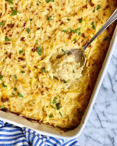 a casserole dish with cheese and parsley on the side, ready to be eaten