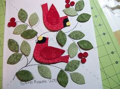 two red birds sitting on top of a green leafy branch with the words germ rosek 2013