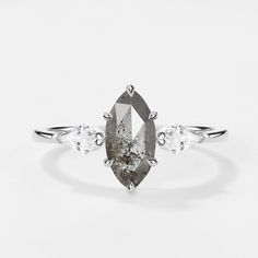 a white diamond ring with three pear shaped diamonds