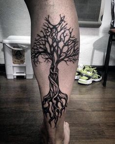 a man's leg with a tree tattoo on it