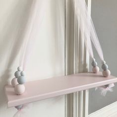 a pink shelf with two balls hanging from it