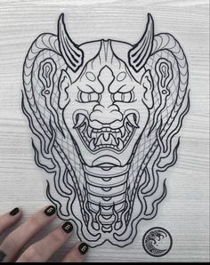 a drawing of a demon head on a wooden surface