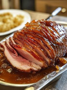 sliced ham sitting on top of a pan covered in sauce