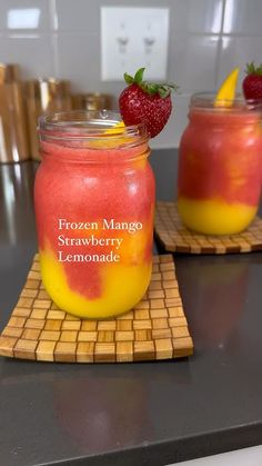 two mason jars filled with frozen mango and strawberry lemonade sitting on top of a counter