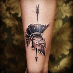 a tattoo on the leg of a person wearing a helmet with an arrow in it