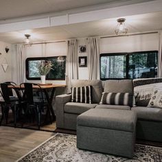 a living room filled with furniture next to a kitchen and dining area in a mobile home