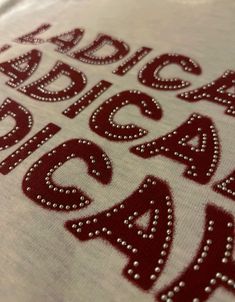 a close up view of the letters and numbers on a t - shirt with beading