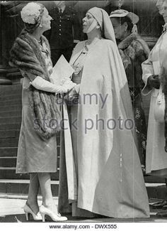 an old photograph of women in dress and fur coats talking to each other on the steps