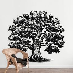 a large black and white tree wall decal in a room with a wicker chair