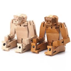 three wooden toy monkeys sitting next to each other