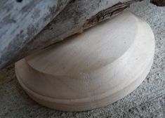 a piece of wood sitting on top of a cement floor next to a tree branch