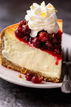 a piece of cheesecake with whipped cream and cherries on top is sitting on a plate