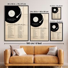 a couch sitting in front of a wall with three records hanging on it's sides