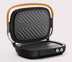 an electric grill with the lid open on a white surface, showing the inside workings