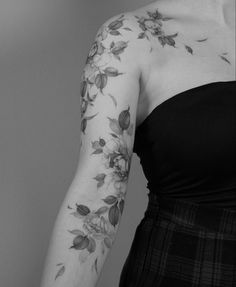 a woman with flowers on her arm in black and white