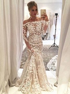 a woman is taking a selfie in her wedding dress, while she looks into the mirror