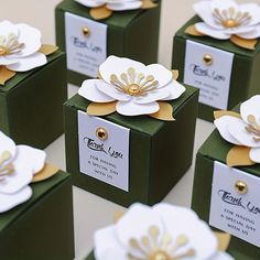 several small boxes with white and gold flowers on them