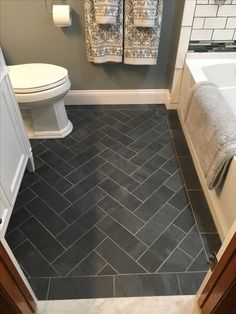 a bathroom with gray tile and white fixtures