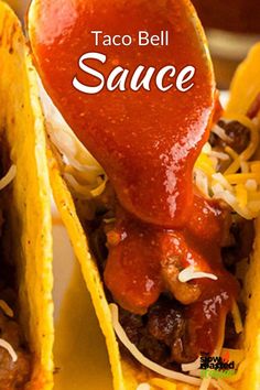 the taco bell sauce is being drizzled on two tacos