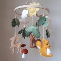 a mobile with animals and trees hanging from it's sides