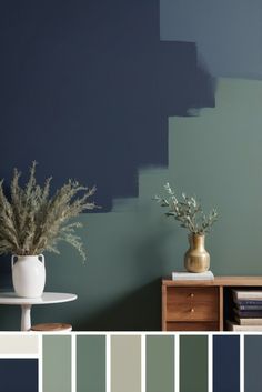 a living room with blue walls and white vases filled with flowers on top of a table