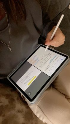 a woman holding an ipad with a pen in her hand