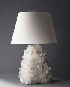 a white lamp sitting on top of a table next to a gray wall and floor