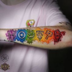 a person with a tattoo on their arm that has different colors and symbols painted on it