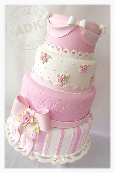 a three tiered cake with pink and white frosting on it's sides