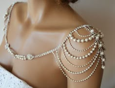 a mannequin with pearls and chains on it's back neck, wearing a white dress