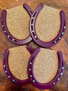 three purple horseshoes sitting on top of a wooden table