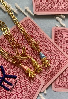 four playing cards with gold chains attached to them