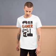 This gamer T-shirt features hand illustrated vintage gaming controllers. The tee makes a fun gift for any gamer that you know. The shirts are 90% combed and ring-spun cotton, 10% polyester. Fabric weight is 4.2 oz (142 g/m2) with pre-shrunk fabric. See our Apparel Sizing Guide for unisex adult T-Shirt sizing. Casual Short Sleeve T-shirt For Gaming Events, Pre-shrunk Graphic Tee For Gaming Events, Cotton T-shirt With Letter Print For Gaming Events, Gamer Cotton Tops With Graphic Design, Graphic Print T-shirt For Gaming Events, Gamer Cotton Top With Graphic Design, Crew Neck T-shirt With Graphic Print For Gaming Events, Gamer Style Graphic Print Short Sleeve Shirt, Gamer Graphic Cotton Top