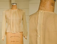 "Antique Silk Blouse Sheer Ivory Button Back Pleated Deco Blouse Beautiful silk blouse. Pleated front with a fitted waistline. Back has metal snap closures with pearl button coverings. Shows normal signs of wear. Measurements shoulders: 13 3/4'' chest: 36\" waist: 33\" length: 20\" sleeve: 23''" Pearl Button-up Blouse For Work, Classic Blouse With Pearl Buttons, Classic Formal Blouse With Pearl Buttons, Workwear Blouse With Pearl Buttons, Classic Fitted Blouse With Pearl Buttons, Formal Button-up Blouse With Pearl Buttons, Fitted Button-up Blouse With Pearl Buttons, Classic Cream Tops With Buttons, Chic Blouse With Buttons For Wedding