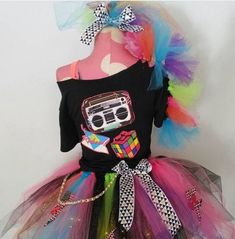 a dress made to look like a doll with colorful hair and glasses on it, sitting on top of a mannequin