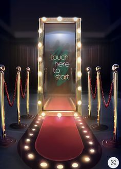 a red carpeted area with a lighted mirror and some barriers in the background that says you're here to stay