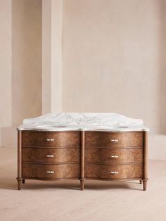 a marble topped wooden dresser in an empty room