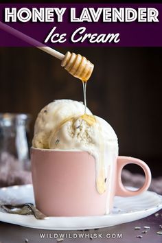 a pink cup filled with ice cream and honey on top of a white saucer