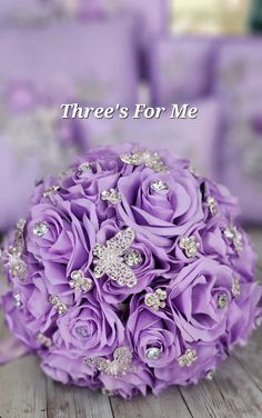 a bouquet of purple flowers sitting on top of a wooden table with the words, three's for me