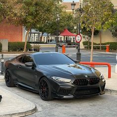 a black sports car parked in front of a red fire hydrant on a city street