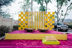 an outdoor ceremony setup with yellow and pink decorations