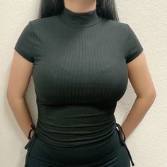 A Super Soft Ribbed Knit Tee With A Mock Neck, Cap Sleeves, And Tying Ruched Side Details. 92% Polyester, 8% Spandex Wearing A Size Small. Black High Neck Top With High Stretch, Black High Neck Sporty Top, Black Sporty High Neck Top, Sporty Black High Neck Top, Black Ribbed Fitted Tops, Black Fitted Ribbed Top, Versatile Black Fitted Top, Black Fitted Versatile Top, Trendy High Neck Black Top