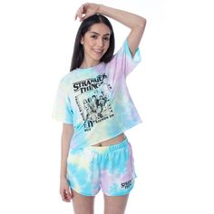 This pajama set is an GREAT Stranger Things loungewear! Stranger Things has become a pop-funure phenom since it was first introduced to us in the summer of 2016. There have since been 3 seasons released with a 4th on the way! This 2 piece Stranger Things lounge set for women features a cropped top shirt and shorts; both have raw-hem edges and a multi-color tie-dye pattern. The top features a large front printed design of 11 characters from the show like Will, Eleven, Dustin, Mike, Lucas, Billy, Stranger Things Print, Stranger Things Logo, Stranger Things Merchandise, Tie Dye Loungewear, Loungewear Set, Tie Dye Patterns, Lounge Set, Pajama Shorts, Lounge Sets