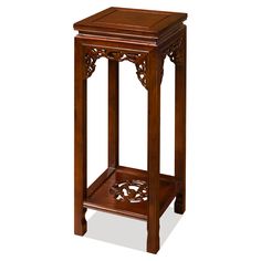 a wooden table with an ornate design on the top and bottom shelf, against a white background