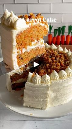 there is a white cake with carrots on the top and one slice missing from it