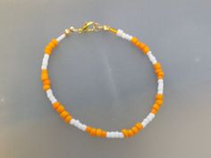 an orange, white and gold beaded bracelet