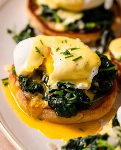 an open face sandwich with eggs and spinach on toasted english muffins