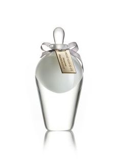 an empty white bottle with a bow on it's top and label in the bottom